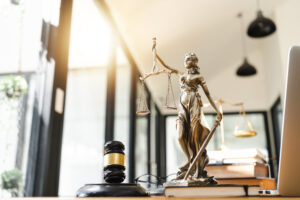 close up of a desk with a brown gavel and lady justice statute in a law office where California pedestrian accident attorneys meet clients for a free consultation